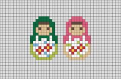 two cross stitch dolls sitting next to each other