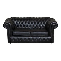 a black leather couch with buttons on the armrests and back rests against a white background