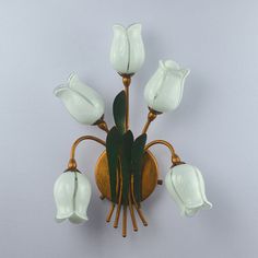 a wall mounted light with white flowers on it