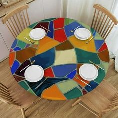 the table is set with white plates and silverware on it, along with two wooden chairs