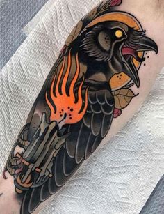 a black bird with flames on it's head is shown in this tattoo design