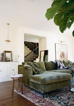 a living room filled with furniture next to a stair case in a white walled room