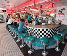 diners are sitting at the counter in a checkered restaurant with blue stools