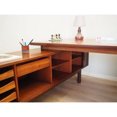 a wooden desk with drawers and a lamp on top