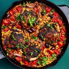 a skillet filled with meat, rice and vegetables