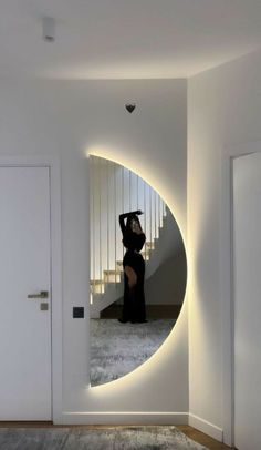 a woman standing in front of a circular mirror