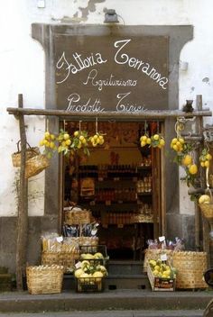 a store front with baskets and lemons on the outside, along with other items