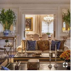 a living room filled with lots of furniture and flowers on top of a coffee table