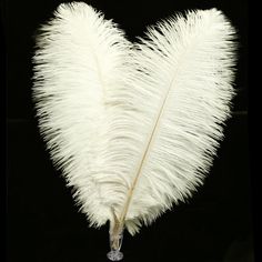 a white feather heart shaped vase on a black background