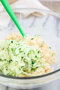 a glass bowl filled with food on top of a marble counter next to a green plastic fork