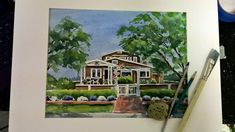 a watercolor painting of a house with trees and bushes in the background next to a paintbrush