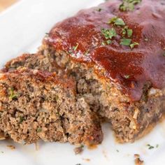 meatloaf with sauce and herbs on a white plate