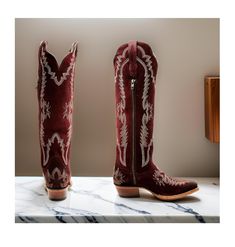 Dan Post Women's Marlowe (Snip Toe) Suede Western Boots Medium Sizes in a bold red hue. These boots are a stylish and sophisticated choice for any Western enthusiast, featuring a striking design and exceptional craftsmanship that sets them apart from the rest. With an impressive 18" shaft height, these Western boots exude confidence and elegance. The 1.75" western heel adds height and flair, while the leather upper and leather outsole with rubber heel cap offer durability and traction for all-da Burgundy Closed Toe Boots For Winter, Burgundy Closed-toe Winter Boots, Western Burgundy Boots With Round Toe, Western Style Burgundy Boots With Round Toe, Red Western Boots For Winter, Red Boots For Rodeo In Winter, Western Red Knee-high Boots, Red Western Knee-high Boots, Burgundy Almond Toe Boots For Fall