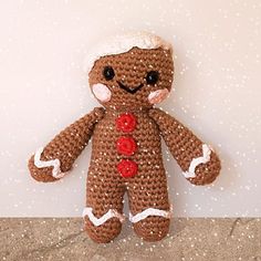 a crocheted gingerbread man sitting on top of a counter next to a white wall