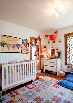 a baby's room with a crib, dresser and bed