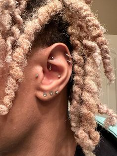 a man with dreadlocks wearing a pair of ear piercings