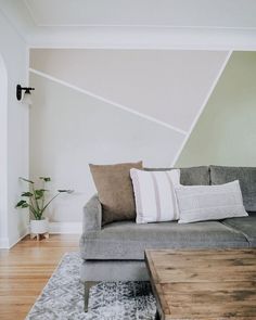 a living room with a couch, coffee table and rugs on the hardwood floor