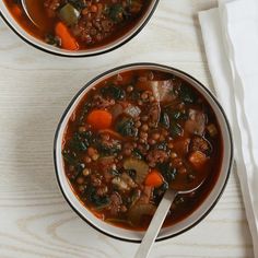 two bowls filled with soup sitting on top of a table