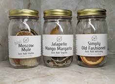 three jars filled with different types of old fashioned spices and seasonings on a marble counter