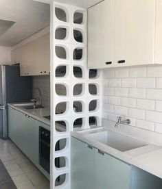 a kitchen with white walls and cabinets next to a sink in the middle of it