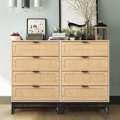 a wooden dresser sitting next to a wall with pictures on it's top and bottom