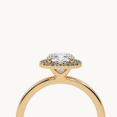 a yellow gold ring with an oval cut diamond on the center and two rows of diamonds around it