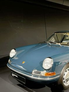 an old blue car is on display in a museum