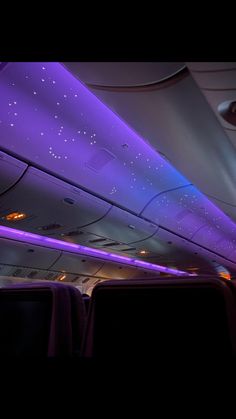 the interior of an airplane with purple lighting