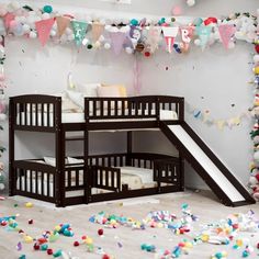 there is a bunk bed with a slide on the bottom and some confetti around it