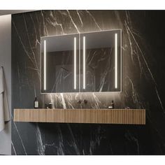 a bathroom vanity with two mirrors and lights on the wall above it, along with a towel rack