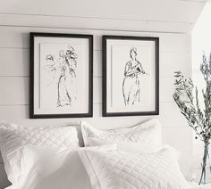 two black and white pictures hanging on the wall next to each other above a bed