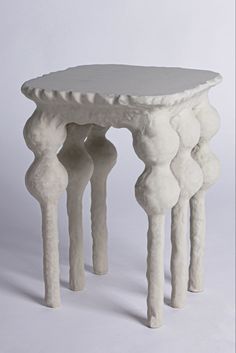 a small white table with three legs on it