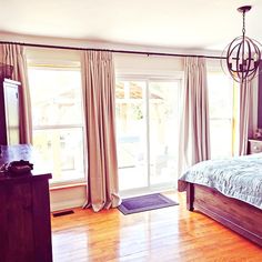 a bed room with a neatly made bed and wooden floors