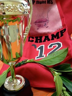 a trophy sitting on top of a table next to a red cloth and green leaves