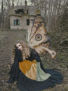 a woman sitting on the ground next to a butterfly