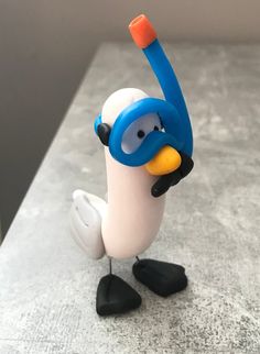 a toy penguin with a diving mask and snorkels on it's head