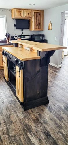 a kitchen with an island made out of wood and black metal bars on the top