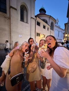 several women are posing for the camera while eating food