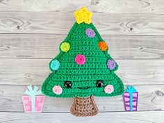 a crocheted christmas tree sitting on top of a wooden table next to presents