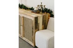 a white chair sitting next to a wooden cabinet with lights on it's sides