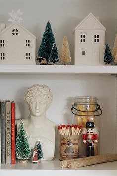 a shelf filled with books and figurines on top of white shelving units