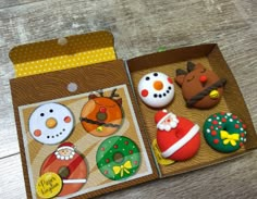 an open box with some decorated cookies in it