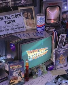 an old tv sitting on top of a table next to posters and other items that have been placed around it