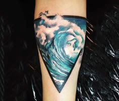 a person with a tattoo on their arm has a wave in the shape of a triangle