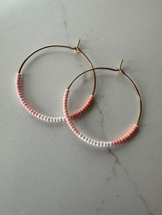 *Medium Sized Hoop Earrings *Three Shades Coral Pink Seed Beads on Gold Hoop *Circle Diameter Approximately 1 3/8" (35mm) These handmade earrings are simple and delicate with dainty coral pink glass seed beads in three shades. They are super lightweight and add the perfect subtle pop of color to your look. They will arrive beautifully packaged and make a perfect gift! Seed Bead Hoop Earrings, Bead Hoop Earrings, Beaded Hoop Earrings, Beaded Hoops, Glass Seed Beads, Pink Glass, Jewelry Earrings Hoops, Gold Hoop, Gold Hoop Earrings