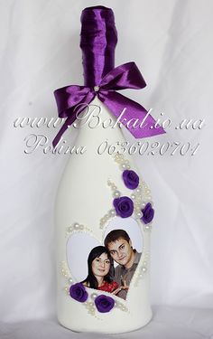 a white bottle with purple roses and two photos on it