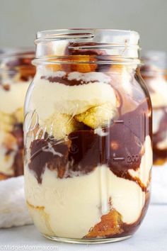 two jars filled with dessert sitting on top of a table