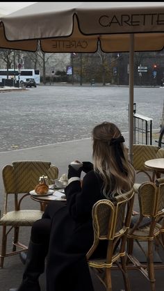 a woman sitting at an outdoor cafe table