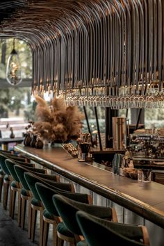 the bar is lined with chairs and wine glasses hanging from it's long ceiling