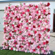 a large pink and red flowered wall in front of a building